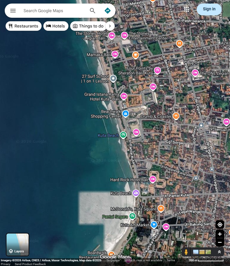 Kuta中央长沙岸与岸后道路;海面保留原始拼接色差。 Google Maps卫星图;2026-09-10查看,北向上。