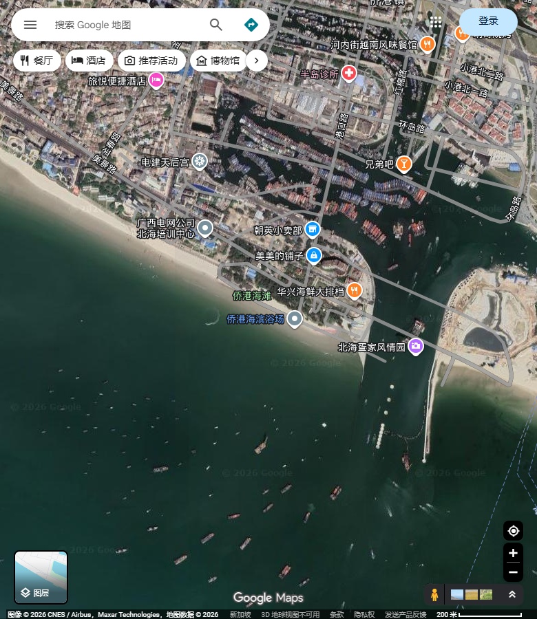 北海侨港海滩、港池与人工岸边。 Google Maps卫星图；2026-09-10查看，北向上。